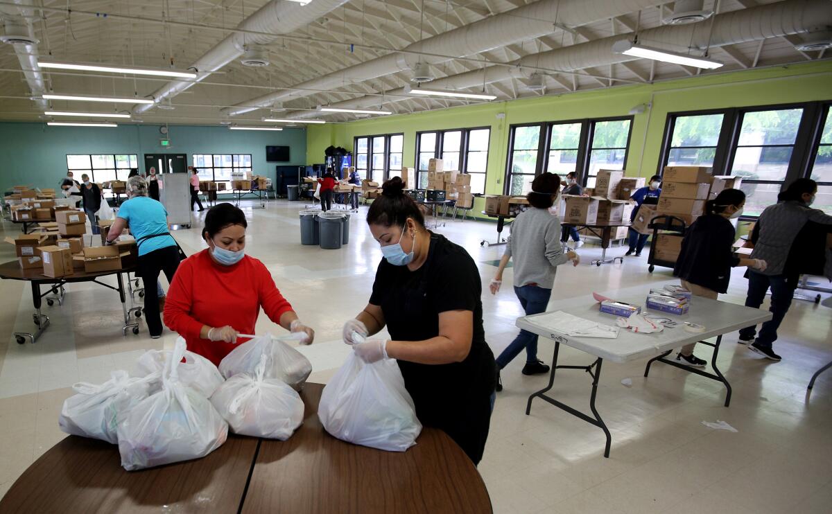 Burbank Unified cafeteria workers prepare five-day meal packages at Burbank Middle School on Tuesday for students throughout the district.