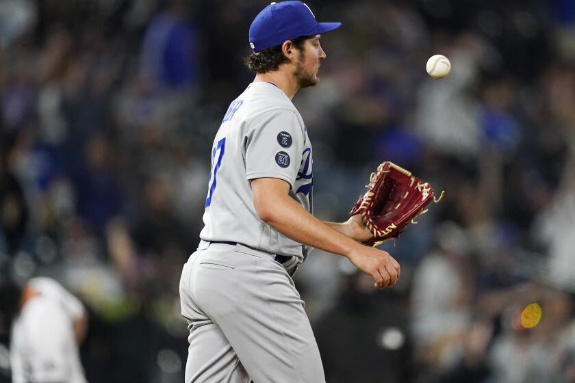 Los Angeles Dodgers starting pitcher Trevor Bauer tosses a new ball after giving up a two-run home run to Colorado Rockies' Ryan McMahon in the seventh inning of a baseball game Friday, April 2, 2021, in Denver. (AP Photo/David Zalubowski)