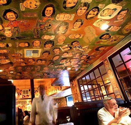 The caricature-decorated ceiling at The Palm.
