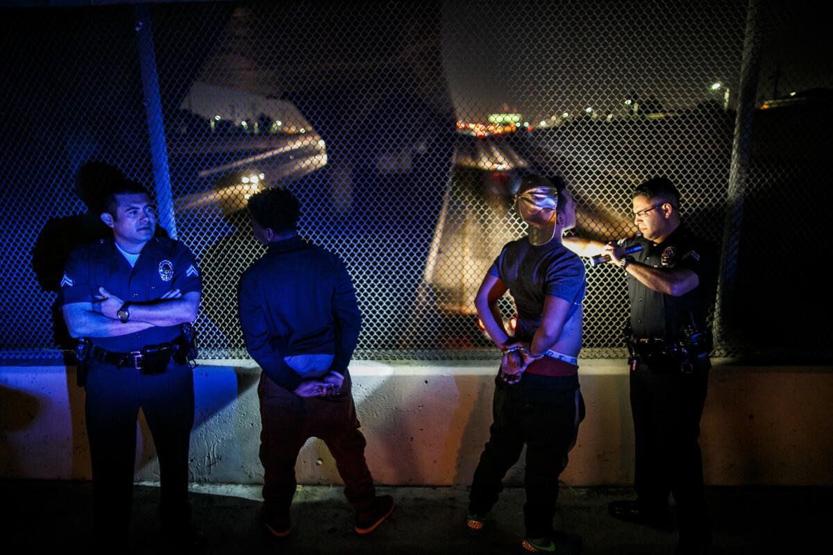 Officers from the LAPD’s Metropolitan Division check a driver and passenger for tattoos while other officers search their vehicle in November 2015.