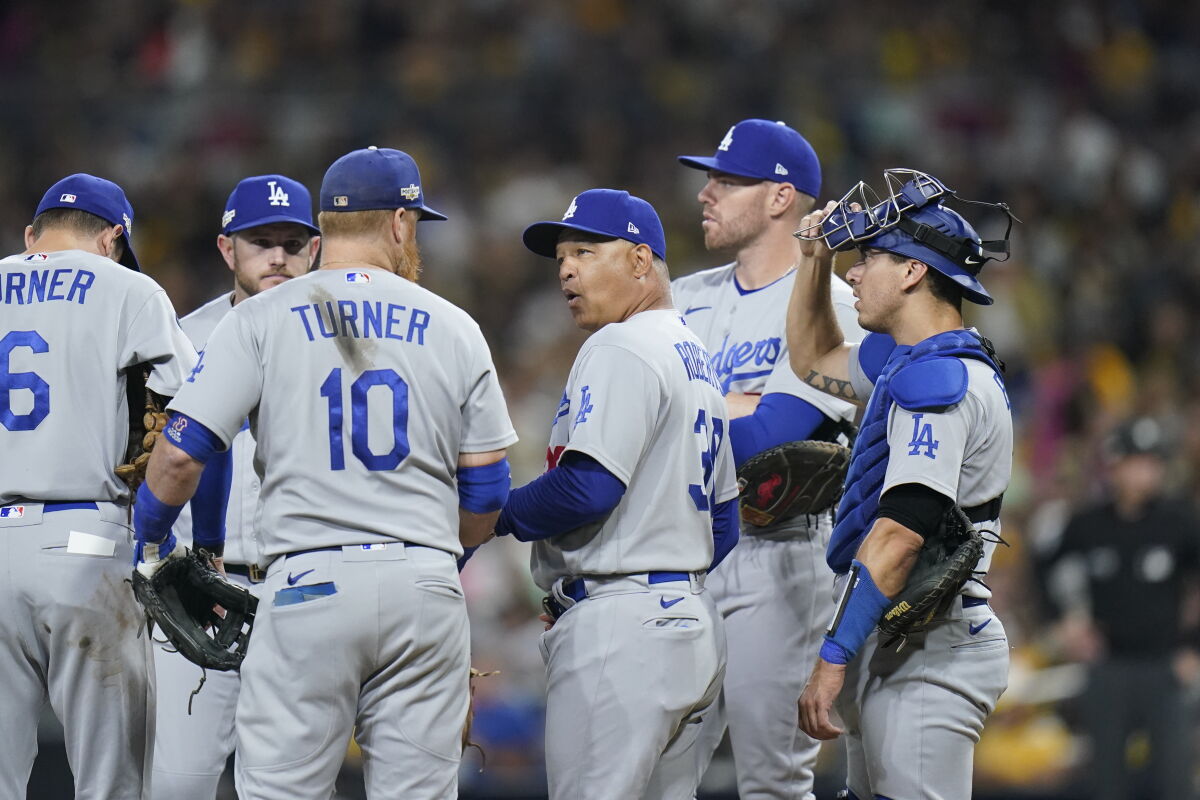 Dodgers manager Dave Roberts meets with players on the mound.