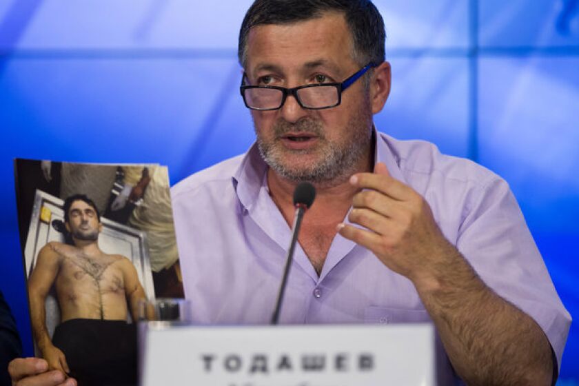 Abdulbaki Todashev holds a photo he claims is of his dead son, Ibragim Todashev, during a news conference in Moscow on Thursday. Ibragim Todashav, a Chechen immigrant, was killed by FBI agents in Florida while being questioned about his ties to one of the Boston Marathon bombing suspects. His father claimed Thursday that Ibragim Todashav had been "executed."