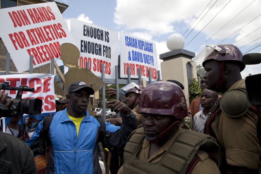 Kenya police stand outside the Kenya Athletic offices in Nairobi, Kenya, Monday, Nov. 23, 2015. A group of Kenyan athletes occupied the headquarters of the national track and field federation on Monday, demanding the removal of its top officials in a protest against doping and corruption. (AP Photo/Sayyid Azim)