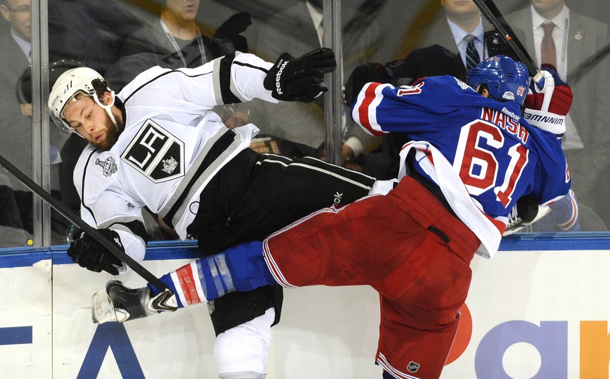 Defenseman Jake Muzzin, shown getting checked by the Rangers' Rick Nash in June, will play with the Kings' split squad at Staples Center on Monday night.