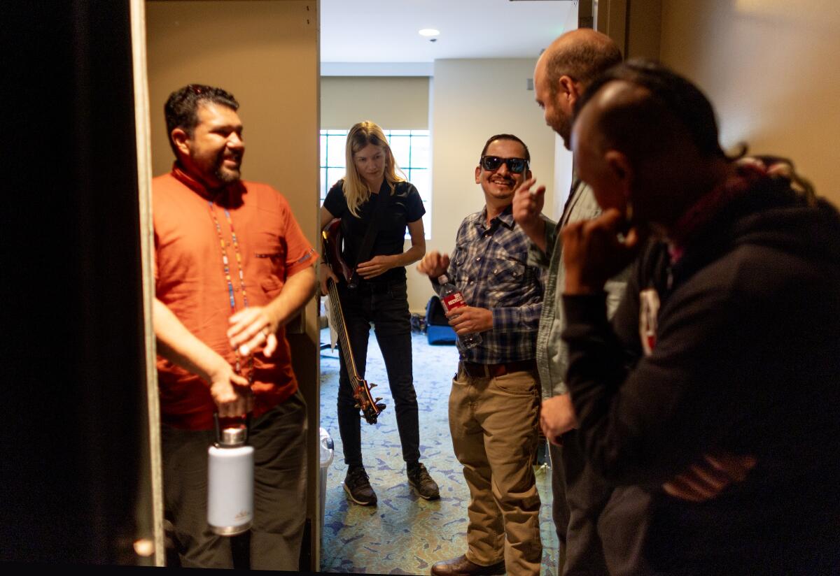 Backstage at the Mark Taper Auditorium, five people stand around joking and smiling.