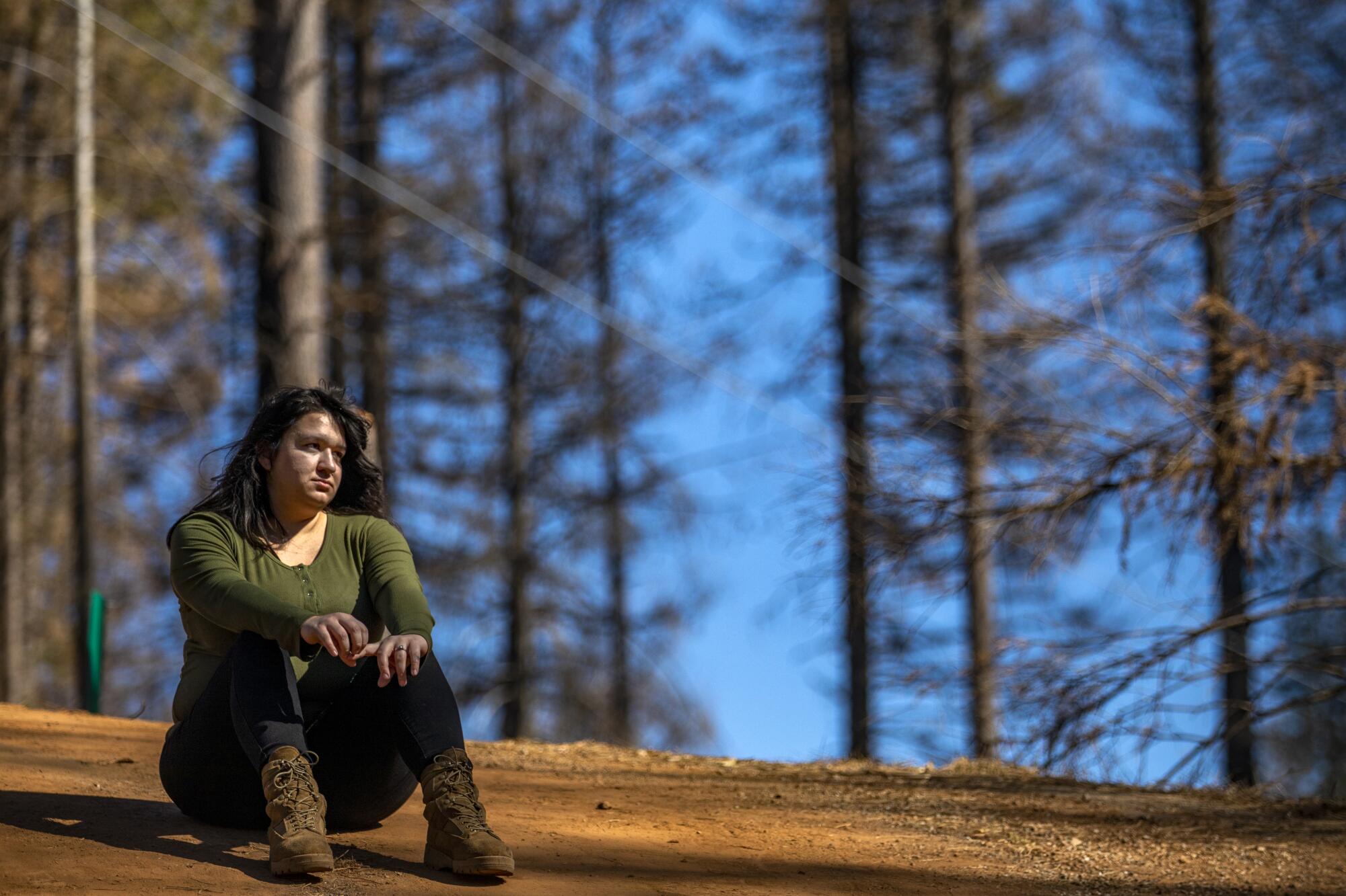 Hannah Hammonds sits on the dirt driveway on her family's property in Grizzly Flats. 