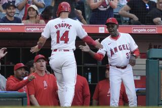 Angels' Logan O'Hoppe (14) high fives manager Ron Washington after scoring off a two-run triple hit by Mickey Moniak