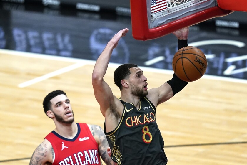 Chicago Bulls' Zach LaVine dunks past New Orleans Pelicans' Lonzo Ball during the first half of an NBA basketball game Wednesday, Feb. 10, 2021, in Chicago. (AP Photo/Charles Rex Arbogast)