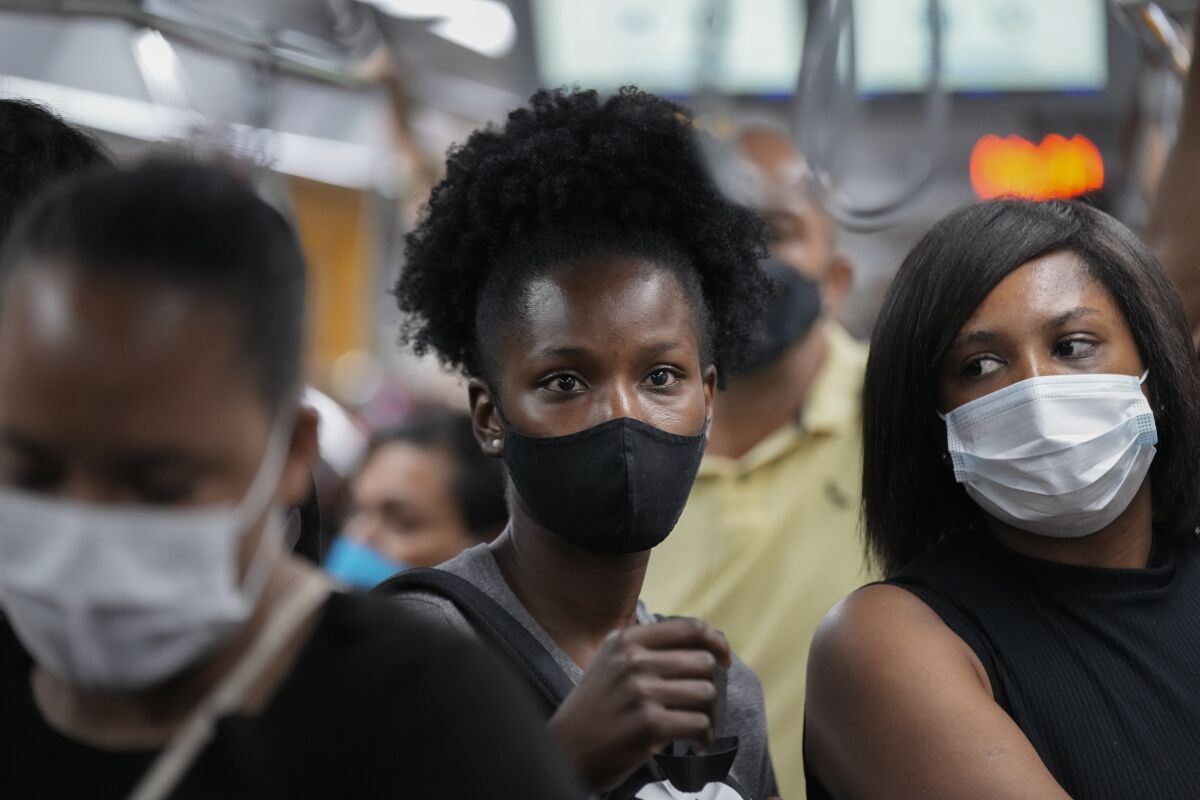 Commuters wear protective face masks as they walk through a subway station, in Sao Paulo, Brazil, Wednesday, Dec. 1, 2021, amid the COVID-19 pandemic. Brazil joined the widening circle of countries to report cases of the omicron variant. (AP Photo/Andre Penner)