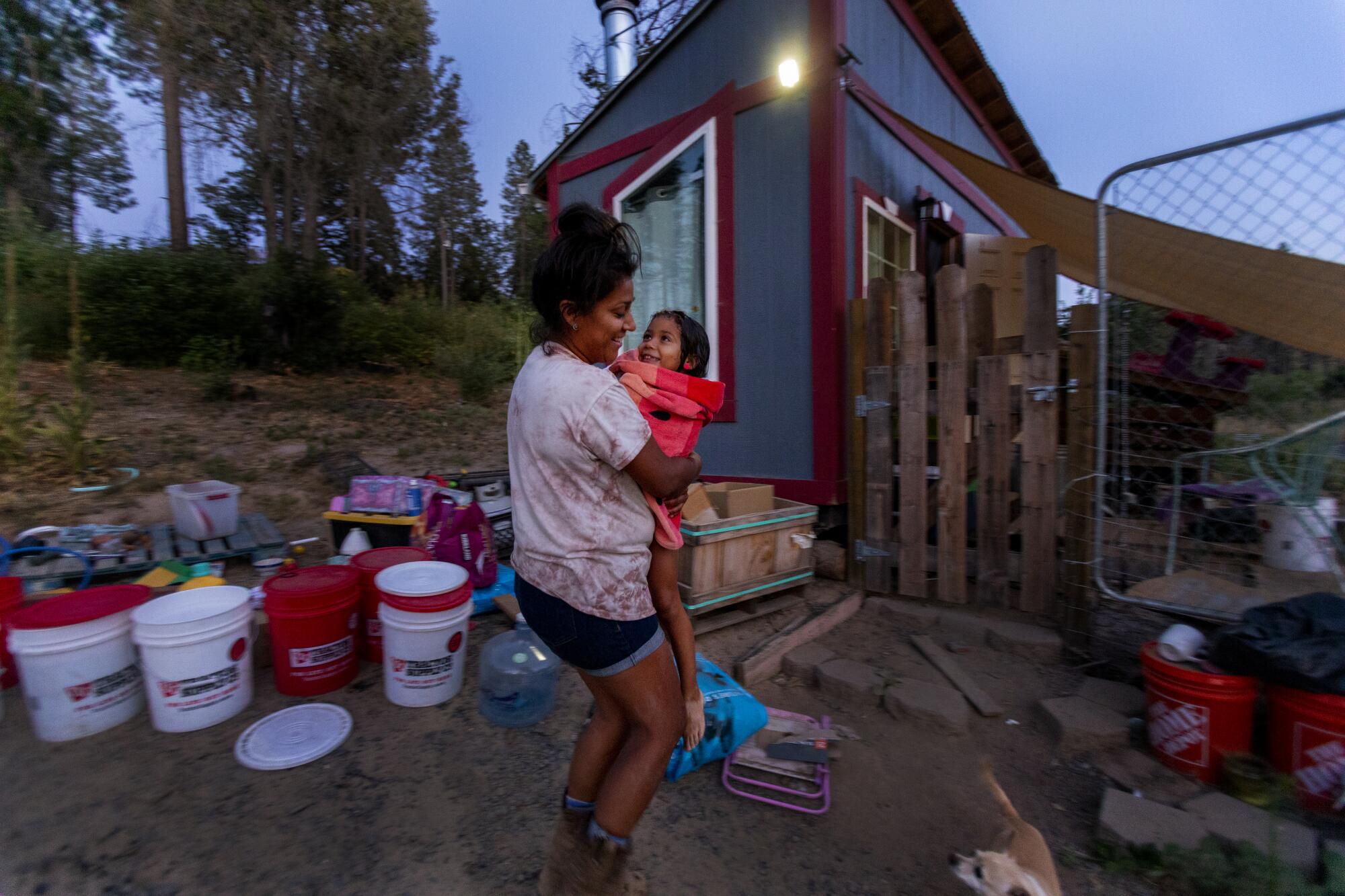 Camp fire victim and volunteer firefighter Inez Salinas carries her 5 year old daughter River