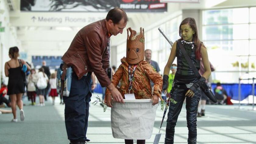 SAN DIEGO, July 24, 2016 | Jeff Hernandez helps adjust the Baby Groot costume his daughter Lianna, 9, is wearing, as they and his older daughter Gabriella, 12, dressed as Gamora, all portray characters in the movie "Guardians of the Galaxy" while walking through the San Diego Convention Center during Comic-Con in San Diego on Sunday. | Photo by Hayne Palmour IV/San Diego Union-Tribune/Mandatory Credit: HAYNE PALMOUR IV/SAN DIEGO UNION-TRIBUNE/ZUMA PRESS San Diego Union-Tribune Photo by Hayne Palmour IV copyright 2016 (San Diego Union-Tribune)