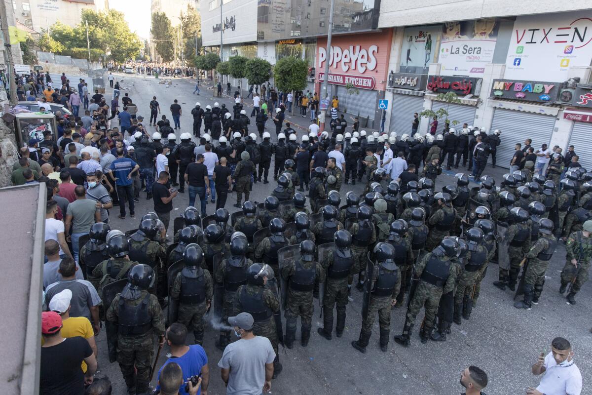 FILE - Palestinian riot police and security officers in plainclothes clash with demonstrators following a rally protesting the death of Palestinian Authority outspoken critic Nizar Banat, in the West Bank city of Ramallah, Saturday, June 26, 2021. Palestinian authorities in the West Bank and the Gaza Strip systematically torture critics in detention, what could amount to crimes against humanity, an international rights group said Friday, July 1, 2022. (AP Photo/Nasser Nasser, File)