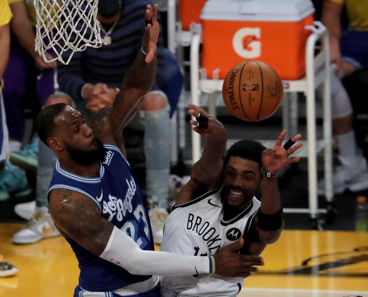 Lakers forward LeBron James defends against Nets guard Kyrie Irving.