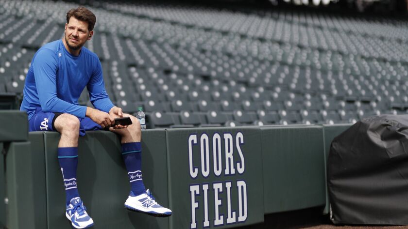 Dodgers pitcher Rich Hill takes a break while warming up before the Dodgers faced the Colorado Rockies on Friday in Denver.