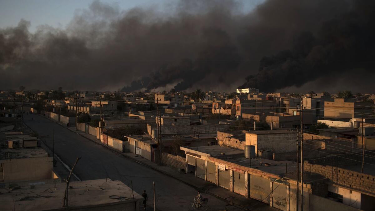 Smoke rises from burning oil fields in Qayyarah, about 40 miles south of Mosul, Iraq.
