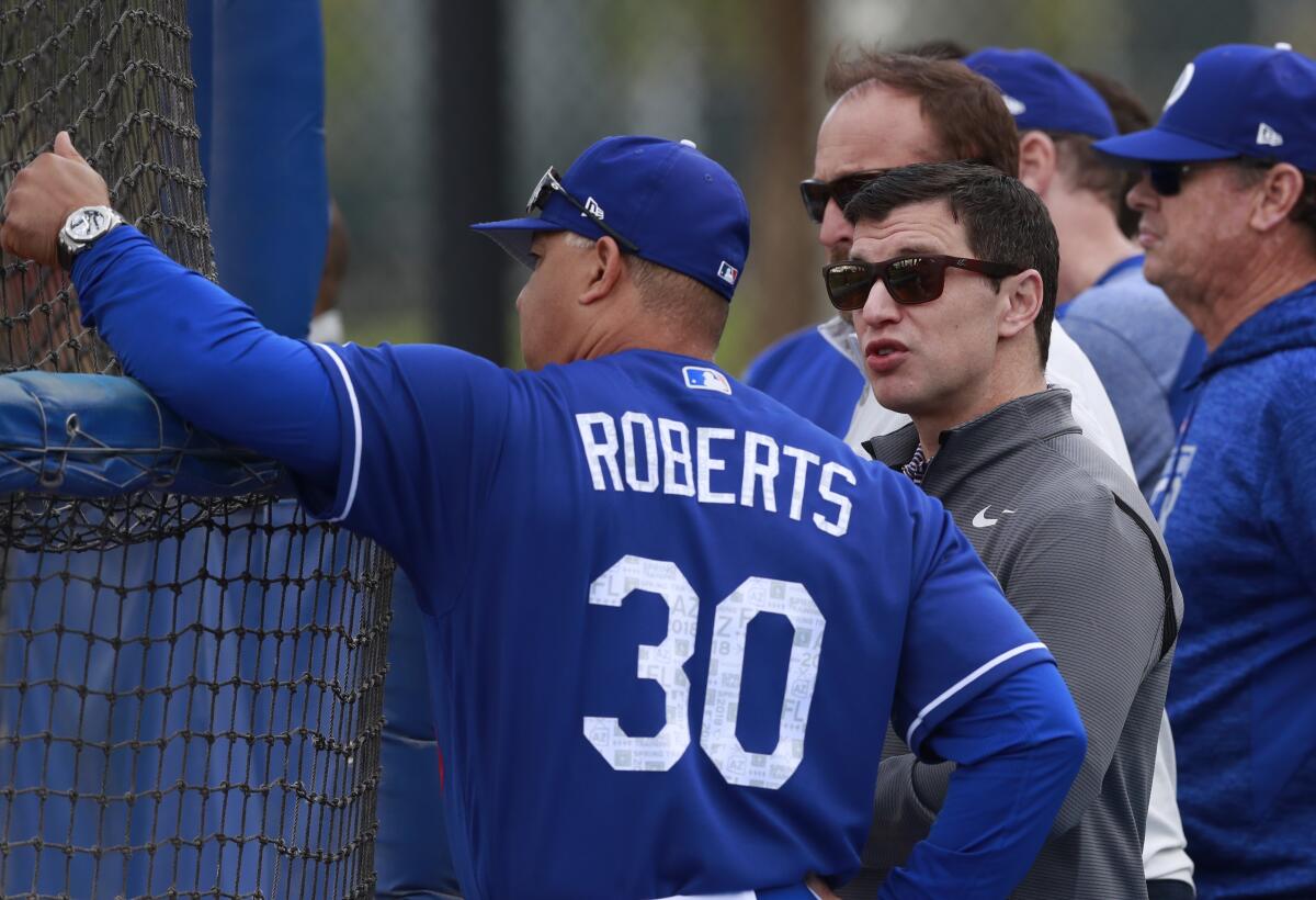 Andrew Friedman, the Dodgers' president of baseball operations, talks with manager Dave Roberts.