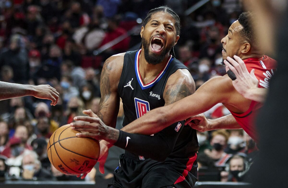 The Clippers' Paul George, left, is fouled by the Trail Blazers' CJ McCollum during the second half Friday night.