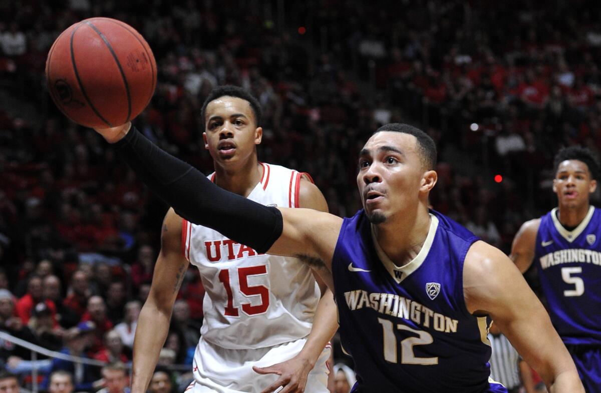 Washington guard Andrew Andrews grabs a loose ball in front of Utah guard Lorenzo Bonam during the second half of the Utes' 90-82 win over the Huskies on Feb. 10.