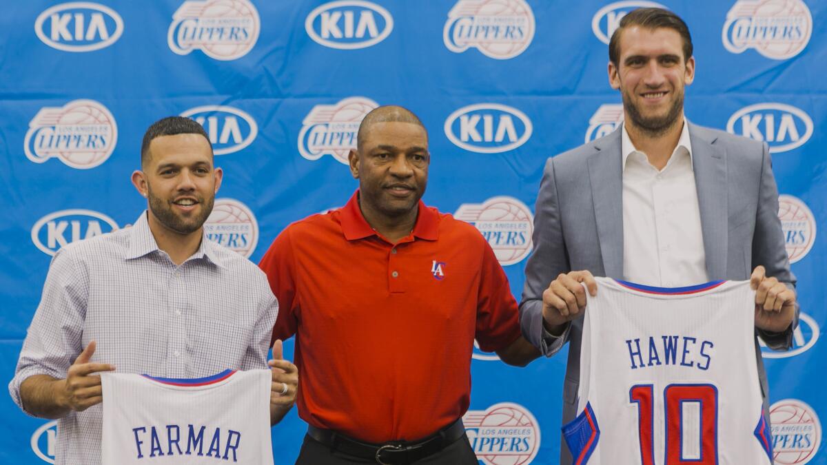 Clippers Coach Doc Rivers, center, poses with his new players, Jordan Farmar, left, and Spencer Hawes during a news conference on July 10. Rivers is pleased with the acquisitions the team has made since the start of free agency.