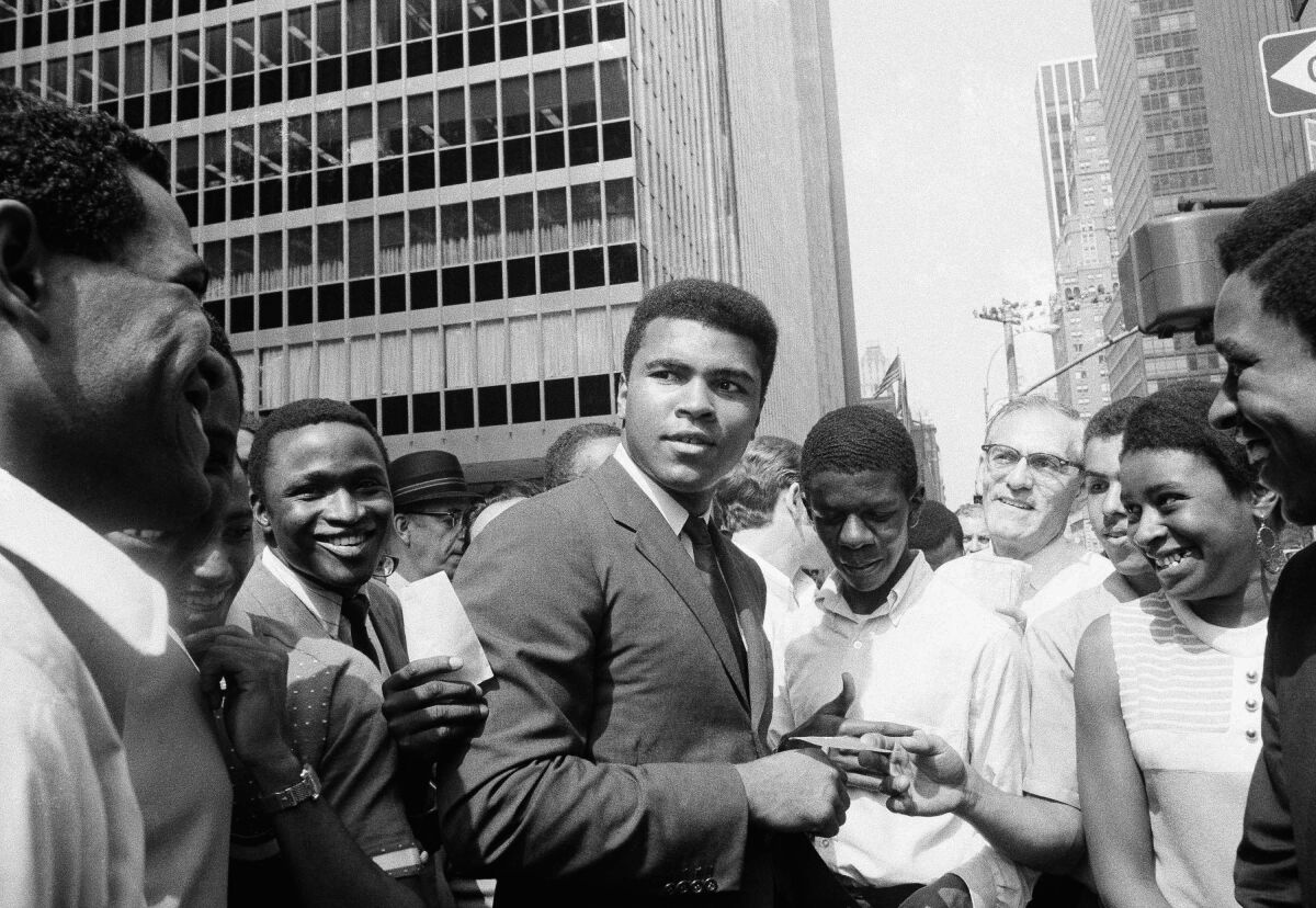 Muhammad Ali surrounded by autograph seekers in Manhattan in 1968.