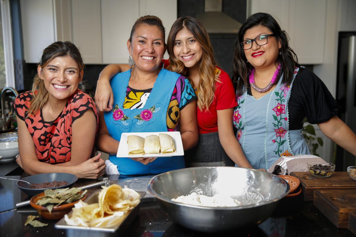 Maria de Jesus, second from left in blue apron, with her daughters Bricia Lopez, left, Elizabeth Lopez, center, and Paulina Lopez Velasquez while making a classic Oaxacan Christmas meal.
