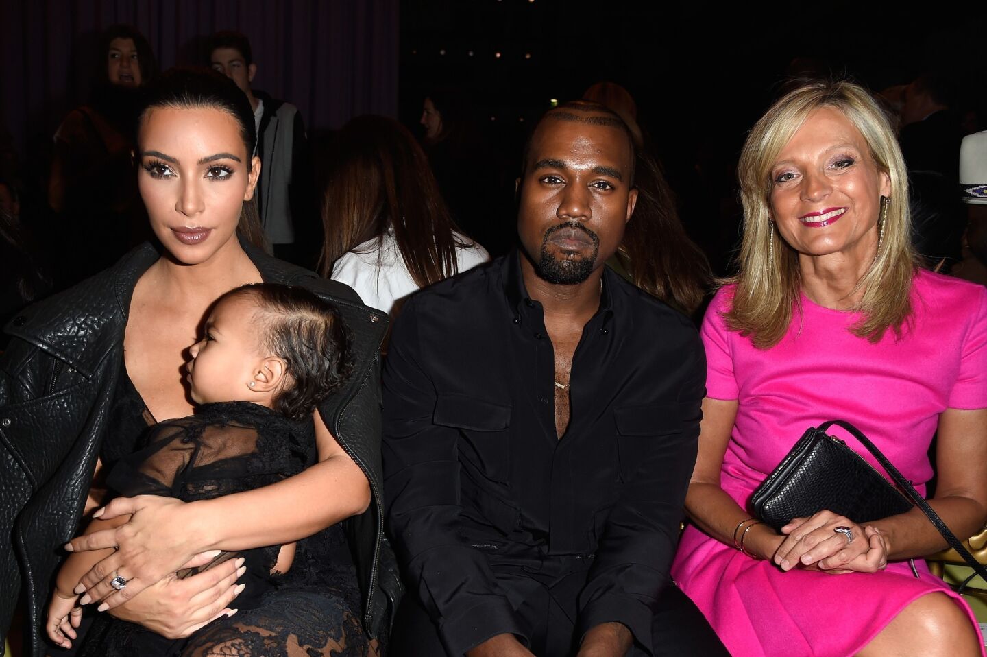 Kim Kardashian, cradling daughter North, Kanye West and pianist Helene Mercier, wife of LVMH CEO Bernard Arnault, sit in the front row at the Givenchy show in Paris. It was the second time the couple had brought their daughter to a show at the spring/summer 2015 womenswear presentations.
