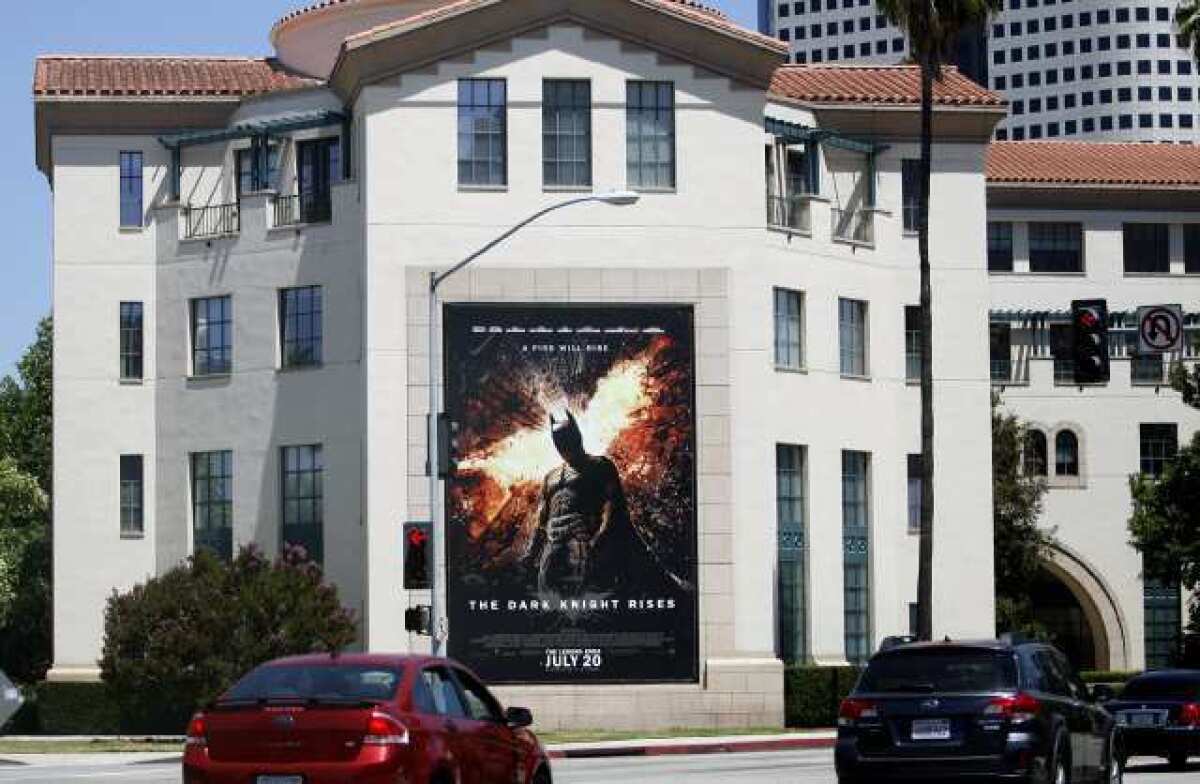 A movie poster promoting the new Batman movie hangs on a building across from the Warner Bros. studios in Burbank on Friday. A massacre occurred in a movie theater in Aurora Colorado at the midnight showing of "The Dark Knight Rises."