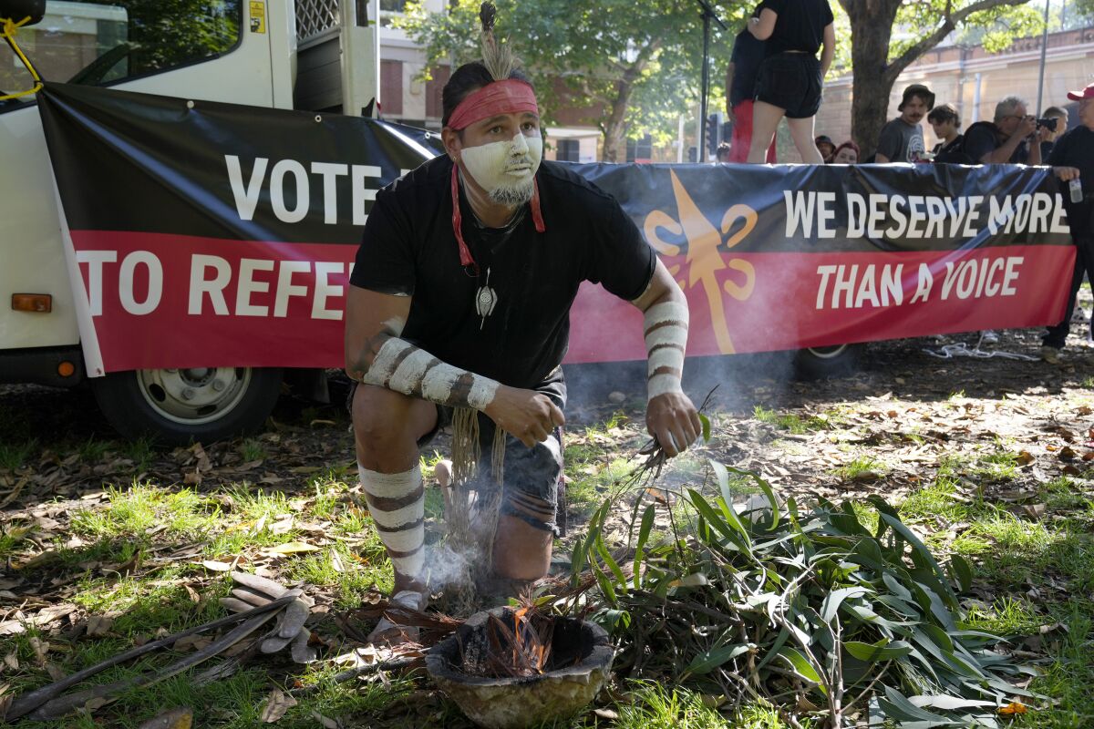 FILE - Aboriginal man Josh Sly of the Muggera Dancers prepares a fire for a smoking ceremony at the start of an Invasion Day rally in Sydney, on Jan. 26, 2023. The Australian government on Thursday, March 23, 2023, released the wording of a referendum question that promises the nation’s Indigenous population a greater say on policies that effect their lives.(AP Photo/Rick Rycroft, File)