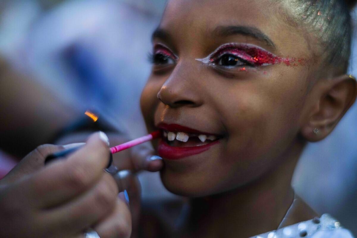 Una niña siendo maquillada antes del desfile de carnaval 