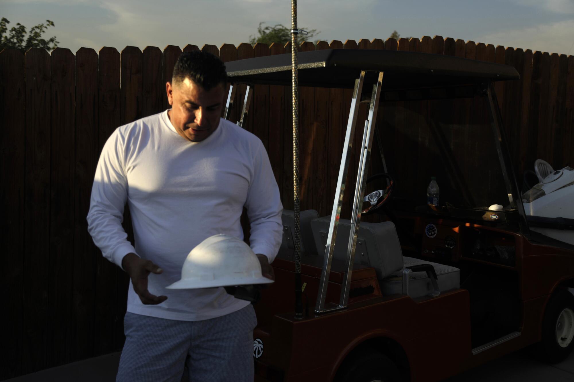  Jorge Valerio, 44, looks at the hardhat that belonged to his father, who died last summer from heat stroke.