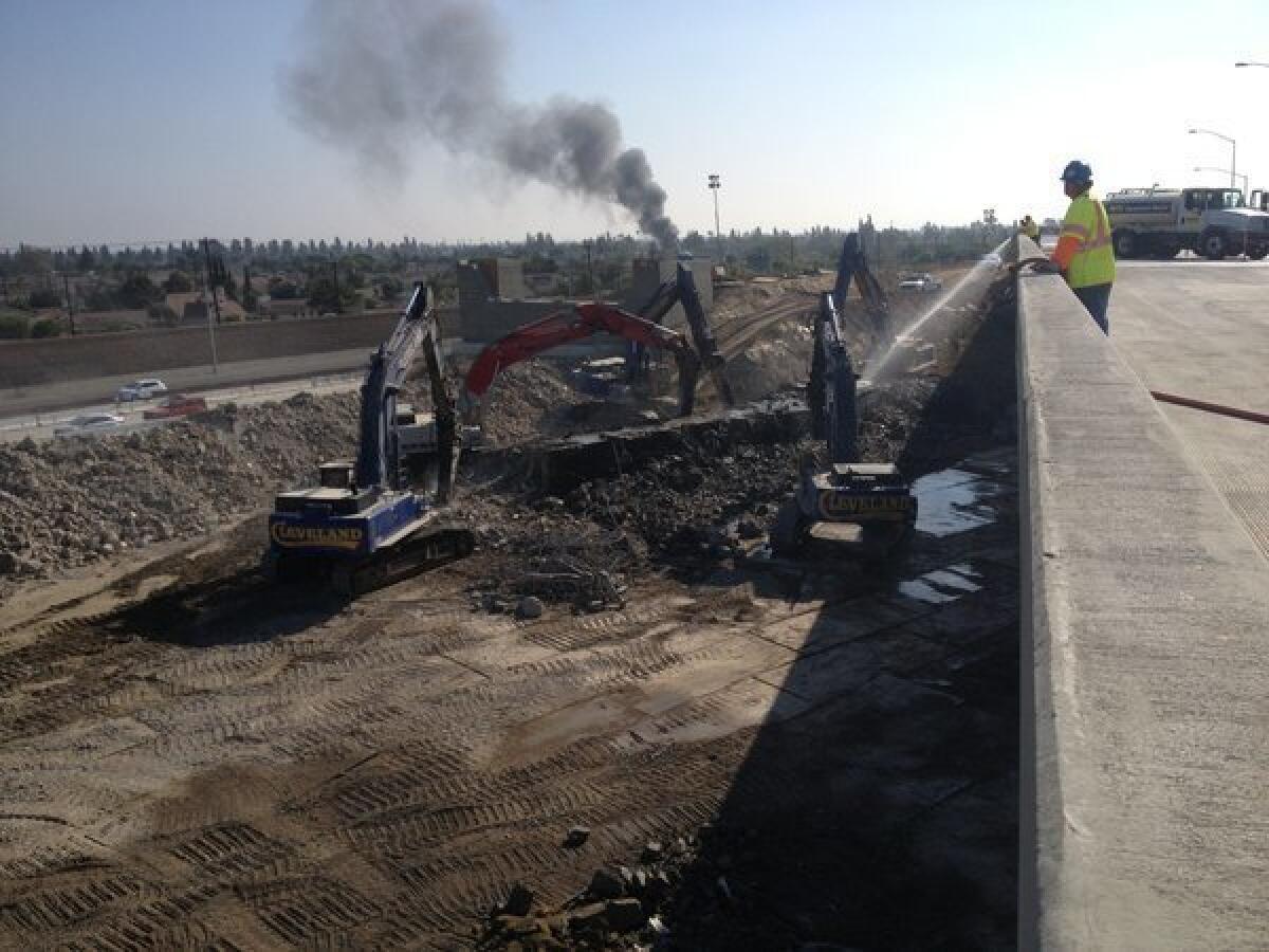Demolition crews work on bridge removal project on 405 Freeway in Orange County.