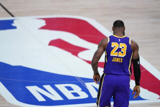  Lakers forward LeBron James (23) walks across the floor toward the NBA logo at midcourt.