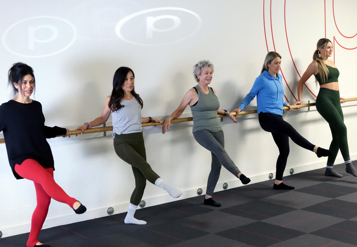 Pure Barre members and instructors work out in at Pure Barre in Huntington Beach on Tuesday.