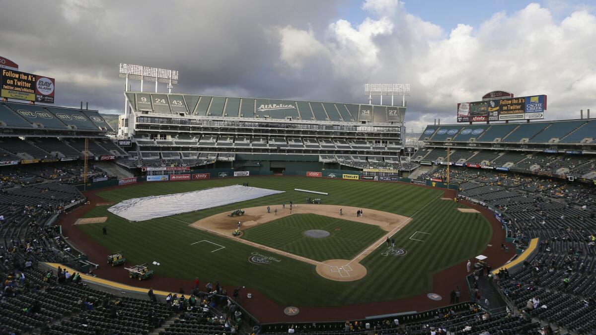 Ground crews work on the O.co Coliseum field before a game between the Oakland Athletics and Seattle Mariners in April.