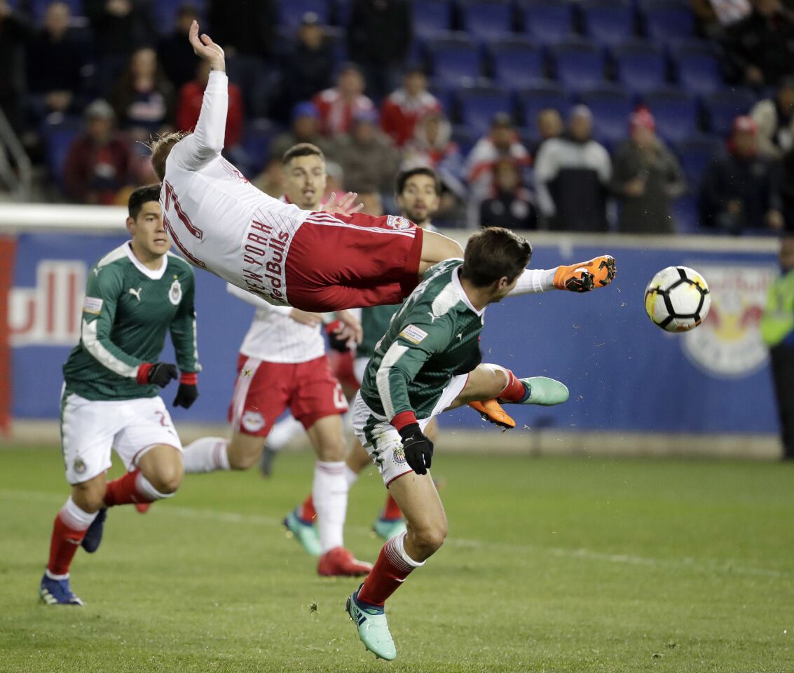 New York Red Bulls midfielder Daniel Royer, top, attempts a bicycle kick as Guadalajara forward Isaac Brizuela defends during the first half of the second leg of a CONCACAF Champions League soccer semifinal Tuesday, April 10, 2018, in Harrison, N.J. (AP Photo/Julio Cortez)
