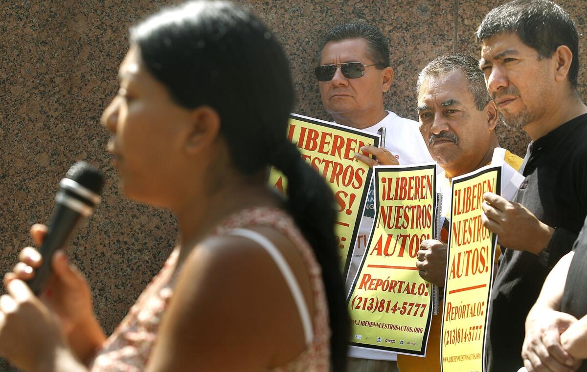 Maria Hernandez, left, tells of being arrested for driving without a license, as supporters of the Free Our Cars Coalition listen at an anti-impound rally this month in downtown L.A.