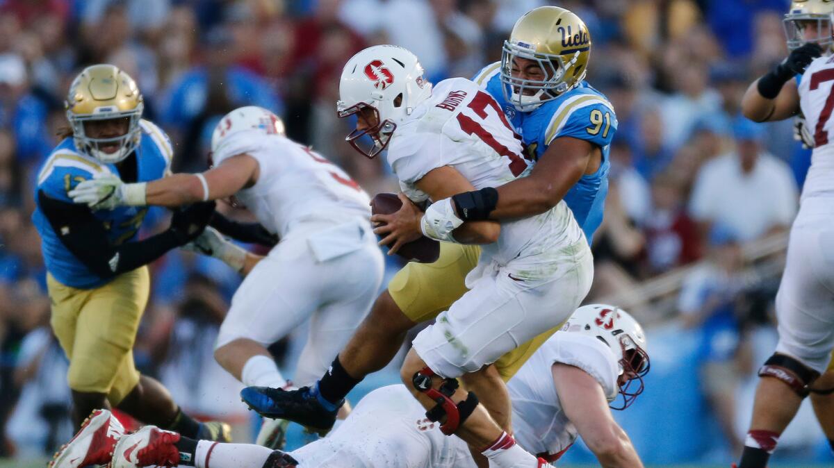 UCLA defensive lineman Jacob Tuioti-Mariner (91) sacks Stanford quarterback Ryan Burns (17) during the first half of a game at the Rose Bowl on Sept. 24.