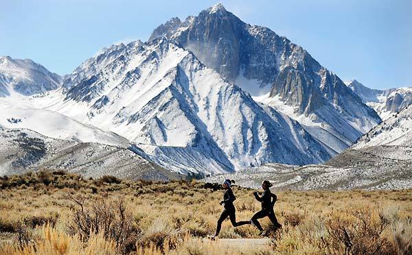 Angela Bizzari, left, and Jen Rhines run along a quiet road near Mammoth Lakes. Training at an altitude of 7,800 feet helps athletes produce more oxygen-carrying blood cells, boosting endurance at lower elevations. Like London: under 100 feet.