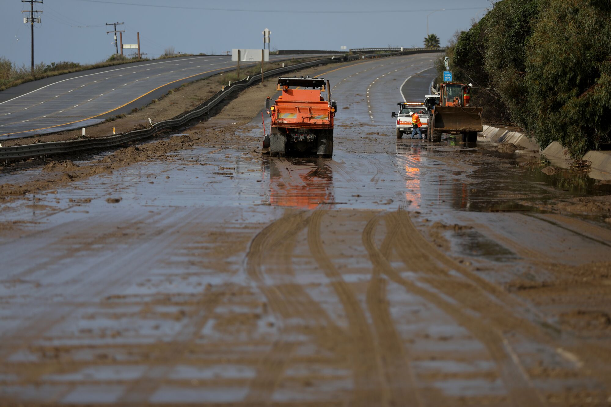 Caltrans removes mud and debris washed up along US 101 northbound lane in Ventura, on Jan. 10.