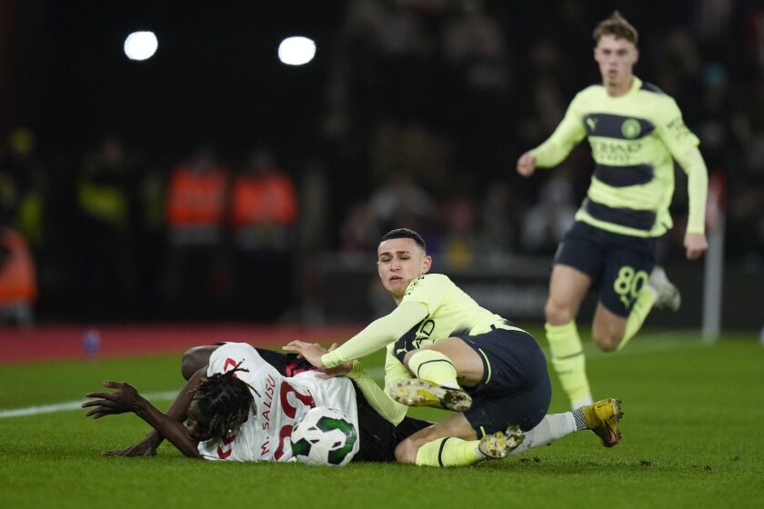 Southampton's Mohammed Salisu, left, fights for the ball with Manchester City's Phil Foden during the English League Cup quarter final soccer match between Southampton and Manchester City at St Mary's stadium in Southampton, England, Wednesday, Jan. 11, 2023. (AP Photo/Alastair Grant)