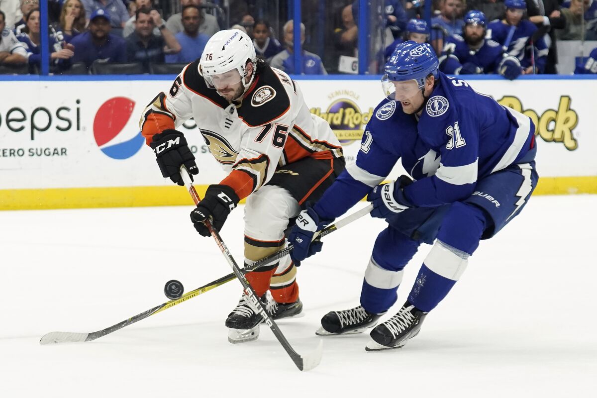 Ducks defenseman Josh Mahura, left, knocks the puck away from Tampa Bay Lightning forward Steven Stamkos.