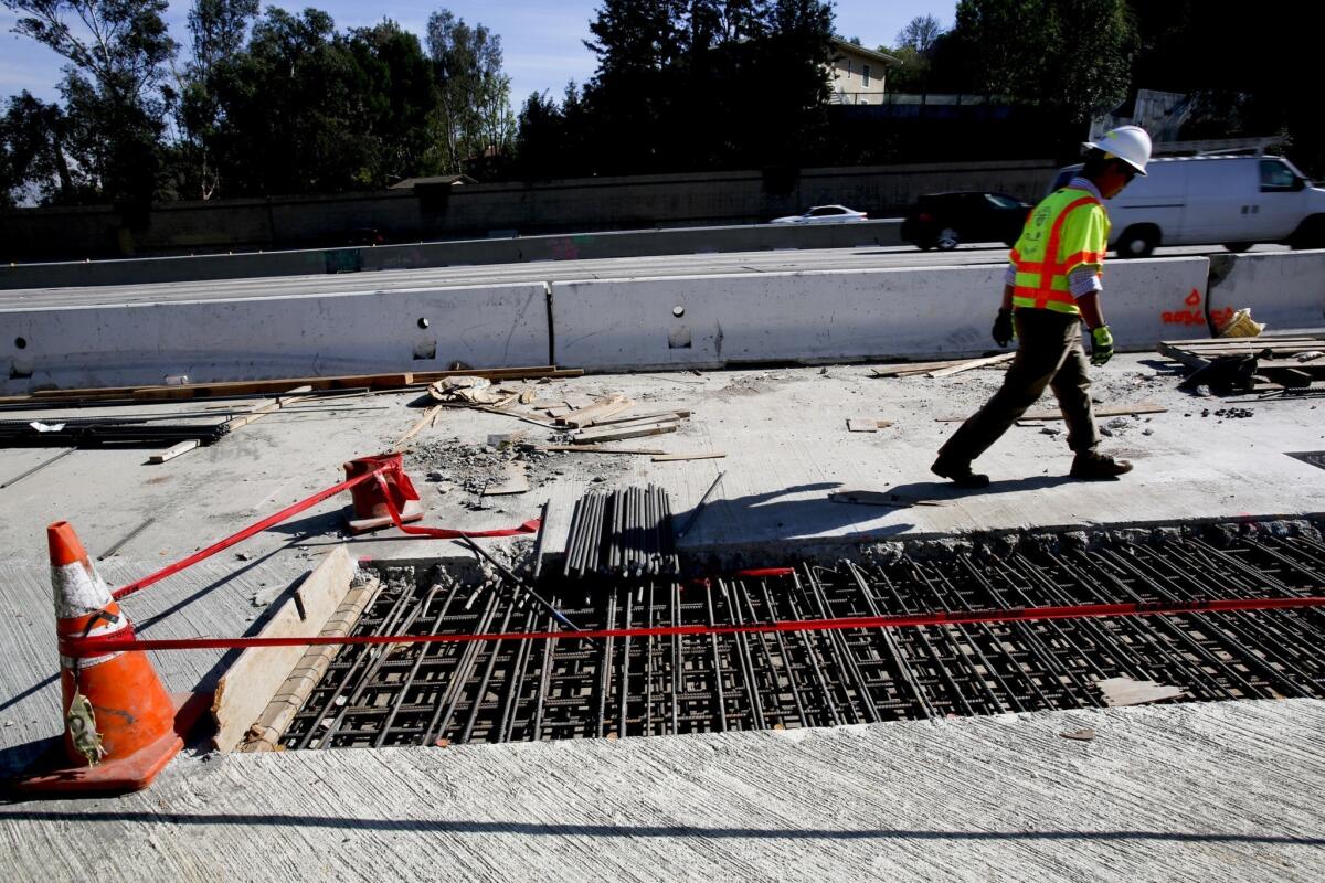 Caltrans engineer Steven Zaw walks past exposed rebar on a section of the 405 Freeway last month during a preview of the Jamzilla paving operation scheduled for the Presidents Day holiday weekend.