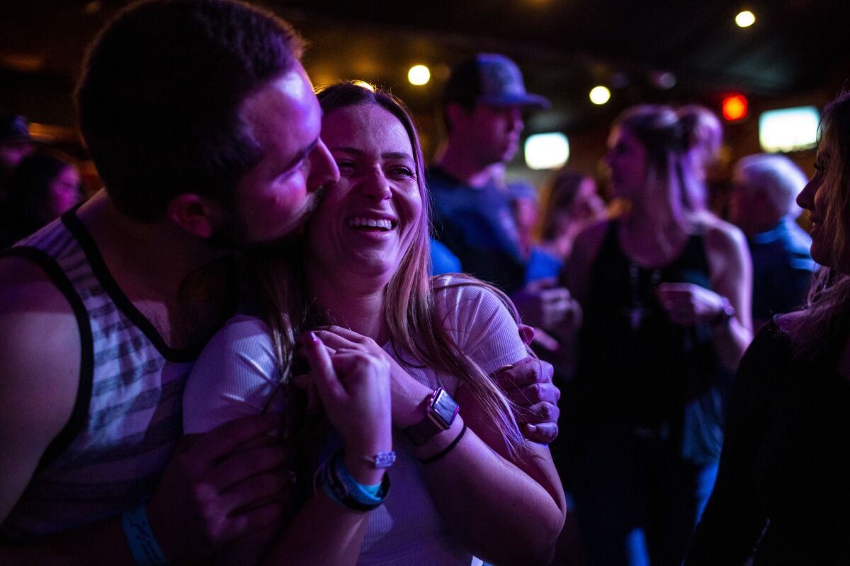 Harrison King, 24, of Thousand Oaks kisses his girlfriend, Alexis Tait, 23, of Simi Valley before hitting the dance floor for line dancing Thursday at Borderline Country Night at The Canyon bar.