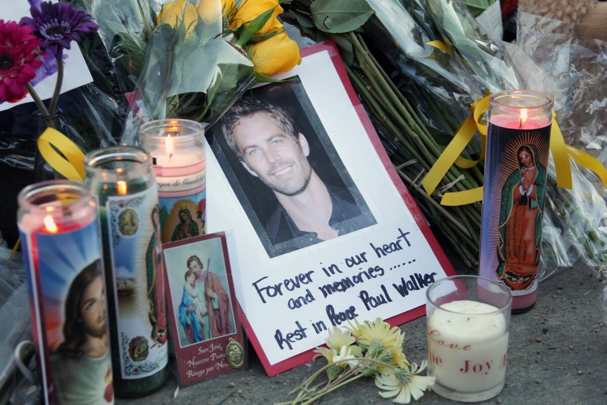 Fans pay tribute to actor Paul Walker at the site of his fatal car accident on Dec. 1, 2013, in Valencia, Calif.