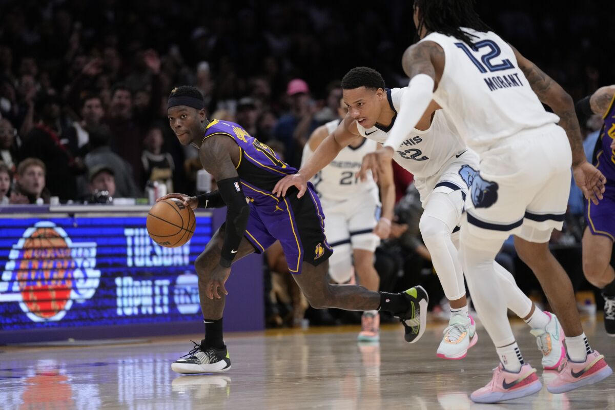 Lakers guard Dennis Schröder, left, controls the ball during the second half of the Lakers' 122-121 comeback win.