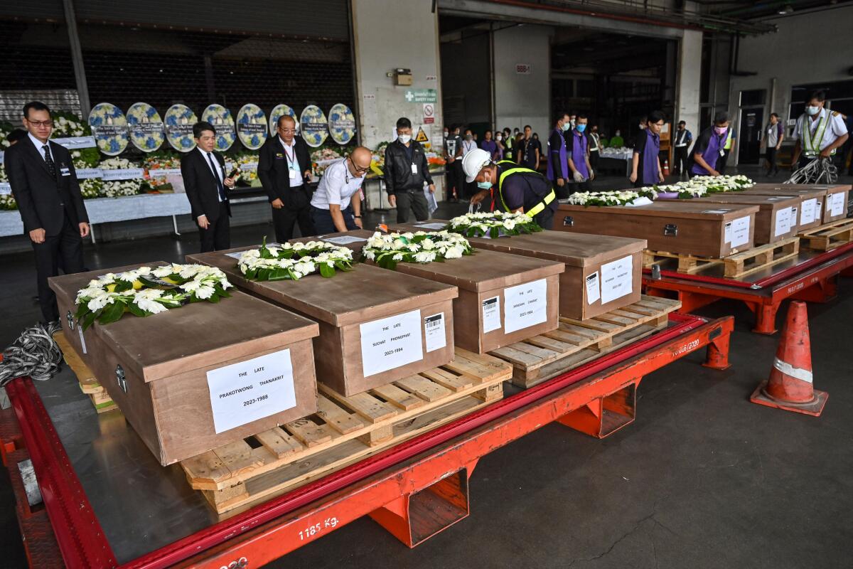 A row of coffins ceremonially displayed at an airport in Bangkok