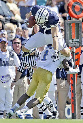 Brigham Young receiver Andrew George tries to leap UCLA cornerback Alterraun Verner during the first half Saturday.