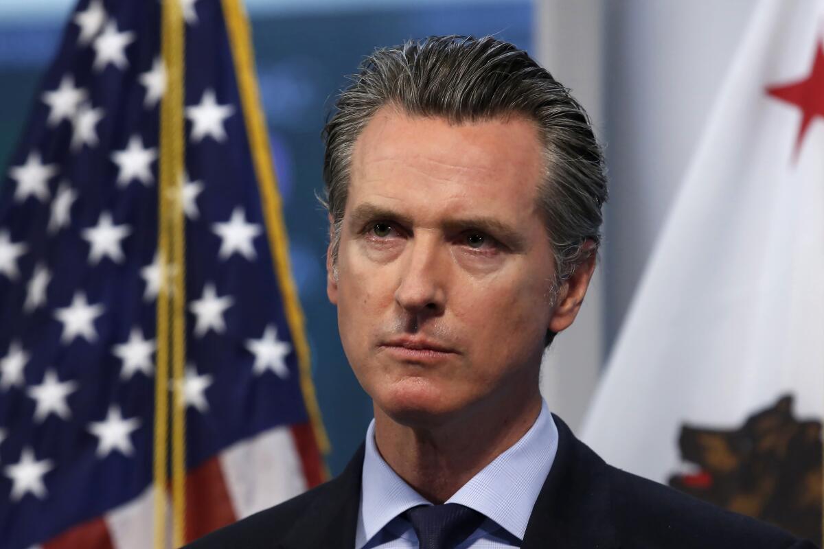 Gov. Gavin Newsom listens to a reporter's question during his daily news briefing in Rancho Cordova, Calif. 