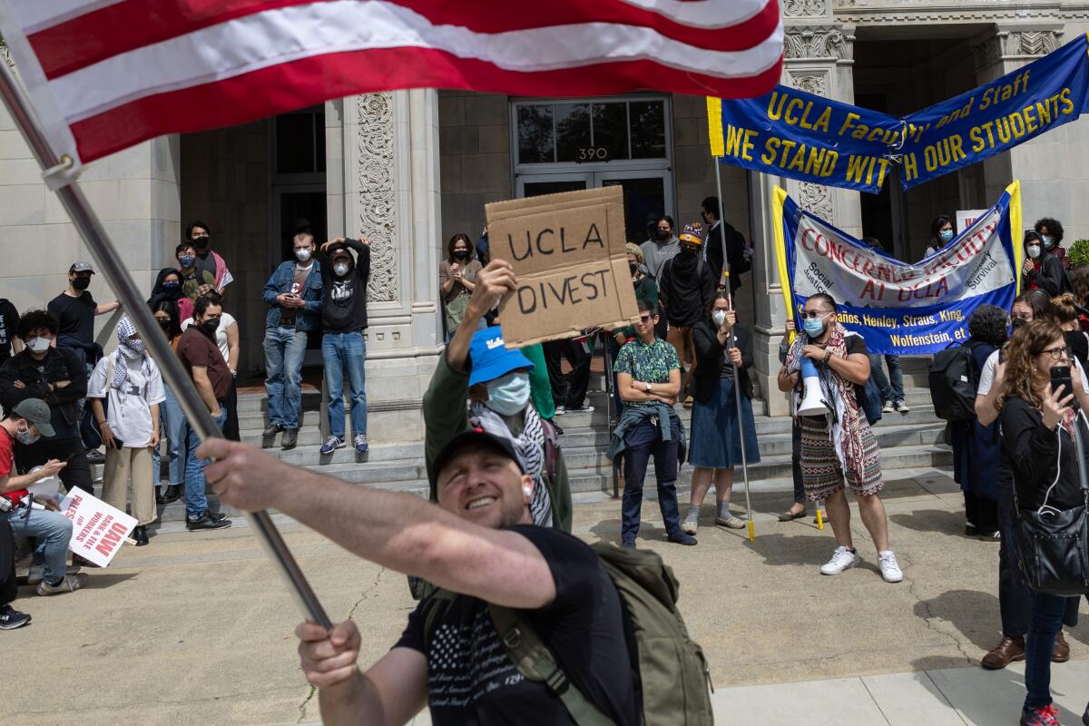 Pro-Israel protesters at UCLA wave an American flag during a pro-Palestinian protest.