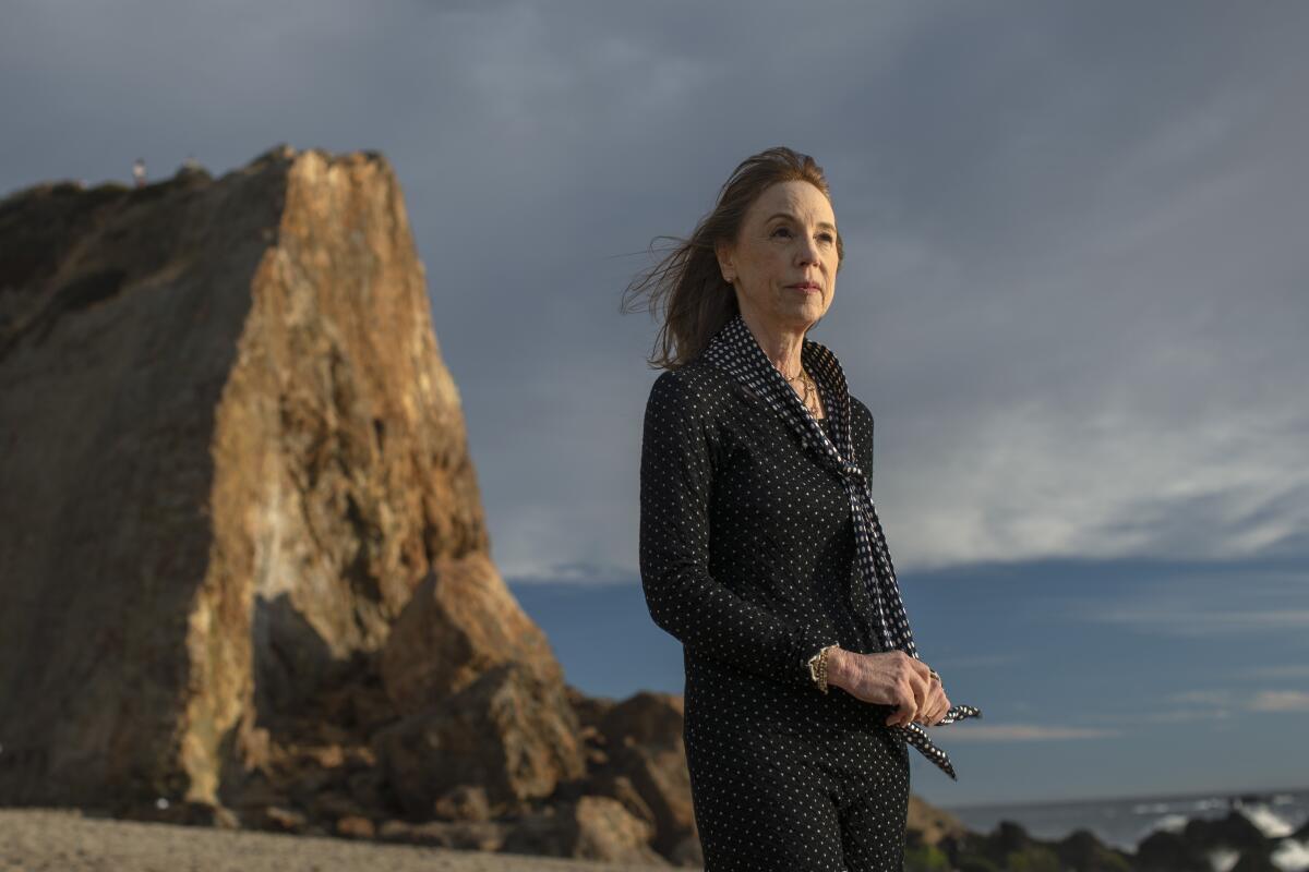 Author Lisa See stands on a rocky coastline